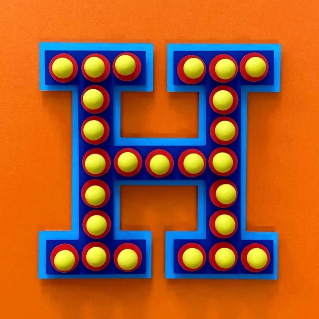 Stylized letter H with yellow circles in red rings and blue outline, against an orange background. Retro-inspired design, flat lay.