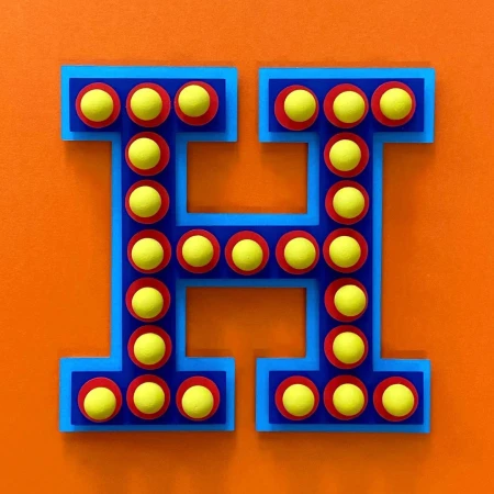 Stylized letter H with yellow circles in red rings and blue outline, against an orange background. Retro-inspired design, flat lay.