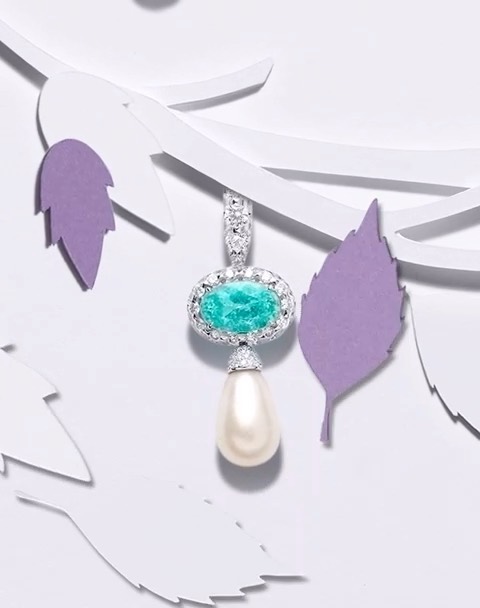 Close-up of a pearl and gemstone pendant necklace with a paper-cut tree branch on a white background. Jewelry advertisement.