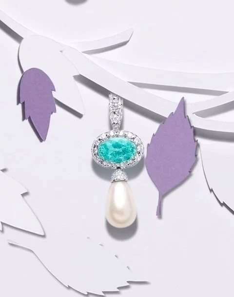 Close-up of a pearl and gemstone pendant necklace with a paper-cut tree branch on a white background. Jewelry advertisement.