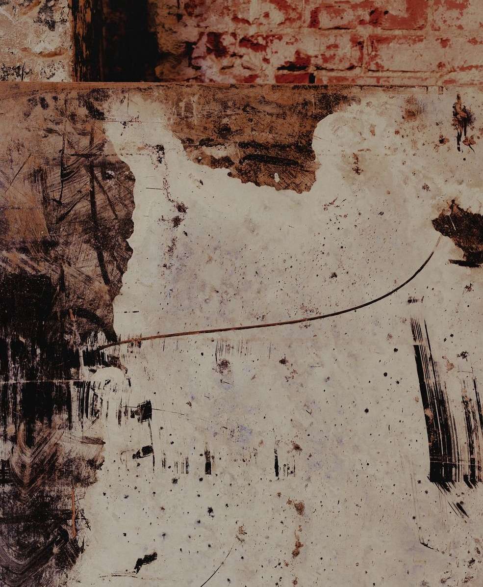 Abstract photo of a distressed wall with exposed brick, peeling paint, and heavy, dark brushstrokes creating a textured, grunge aesthetic.