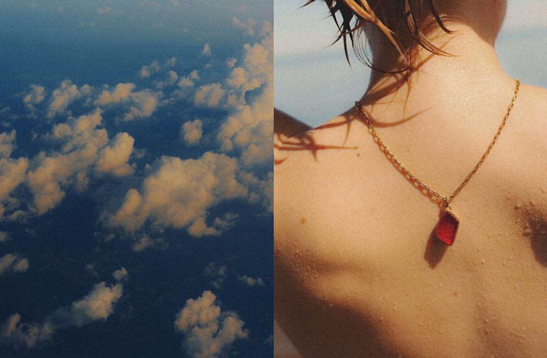 Aerial cloudscape contrasts with a woman's back and gold necklace, creating a juxtaposition of nature and personal adornment.