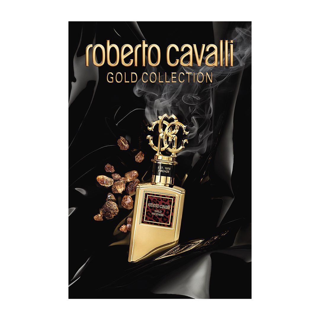 Roberto Cavalli Gold Collection perfume bottle with ornate gold cap and a brown leopard print label, positioned against a glossy black backdrop.