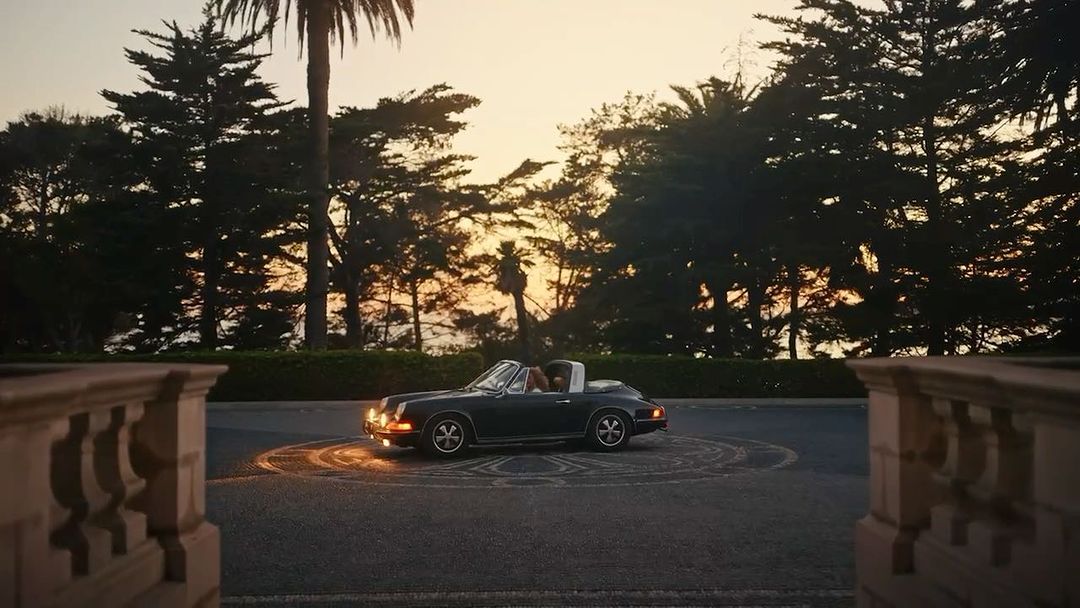 Black convertible car parked on asphalt road with trees in the background during daytime; automotive, landscape, and transportation themes.