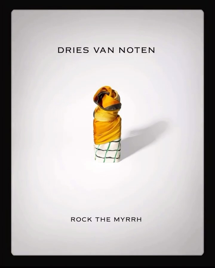 Dries Van Noten campaign featuring a column of folded fabrics in yellow, green, and white, stacked on a white surface.