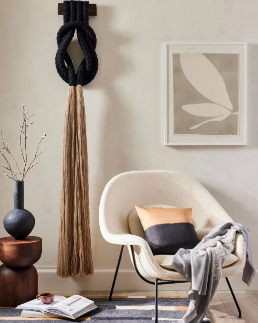 Interior design features a modern chair, wall art, and decorative rope art, creating a stylish and inviting indoor space.