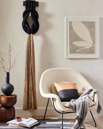 Interior design features a modern chair, wall art, and decorative rope art, creating a stylish and inviting indoor space.