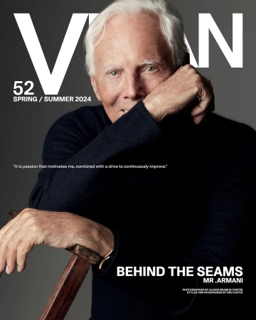 Portrait of Giorgio Armani leaning on a wooden cane wearing a dark sweater against a grey background with magazine typography overlay