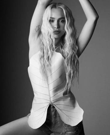 Monochrome portrait of a blonde woman wearing a leaf-shaped halter top and distressed denim shorts, photographed by Alvaro Beamud Cortes.