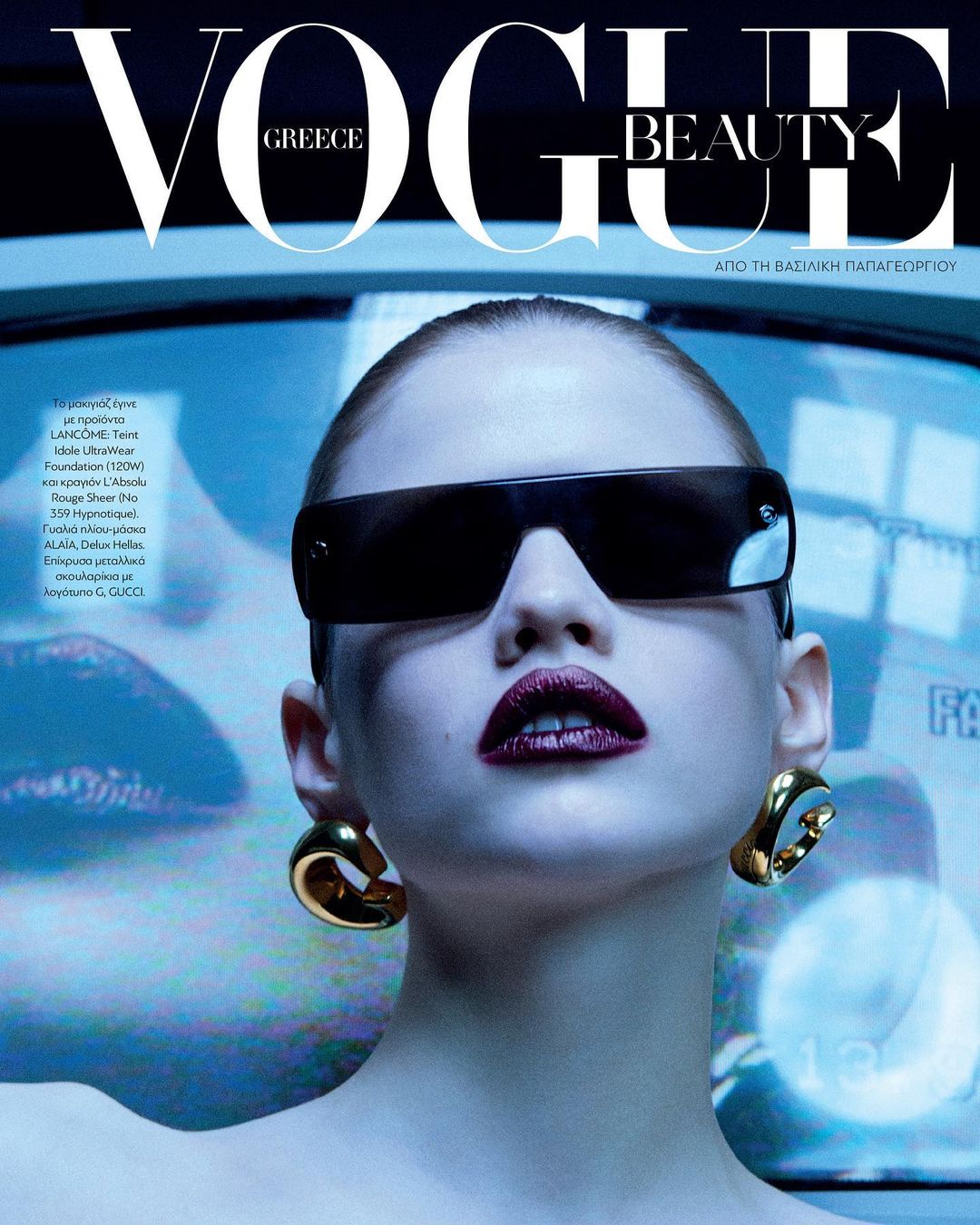 Vogue Greece Beauty cover featuring a model wearing oversized sunglasses, gold earrings, and dark lipstick with a blue backdrop.