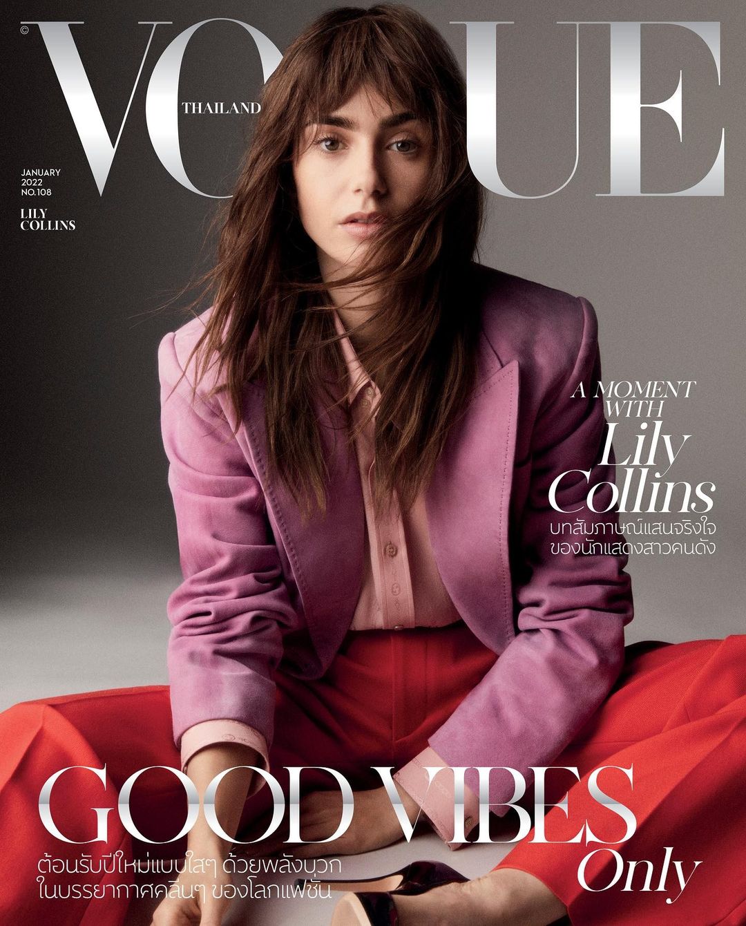 Vogue Thailand cover featuring Lily Collins in a pink blazer and red pants, sitting with dark hair and a neutral expression.
