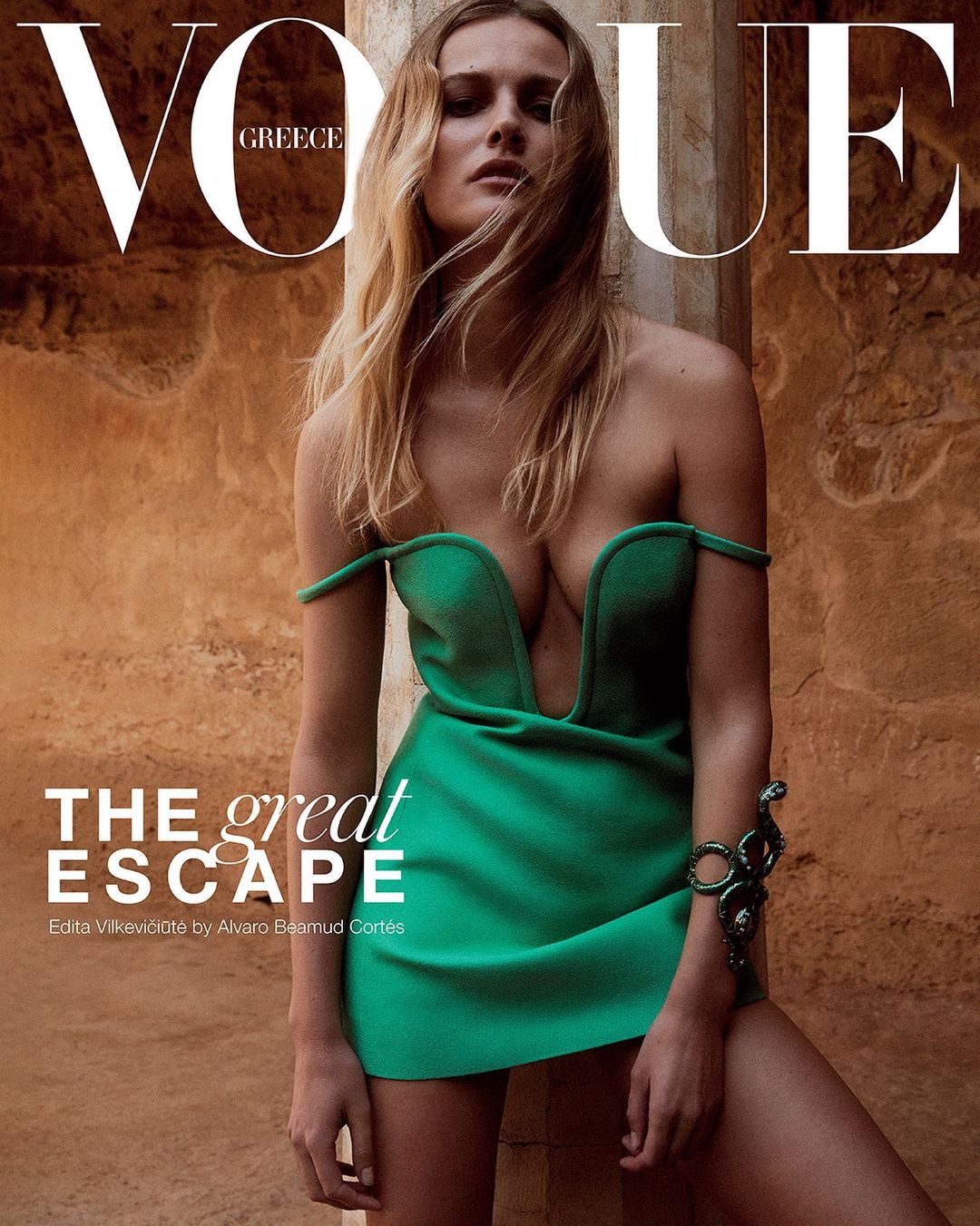 Vogue Greece cover featuring a blonde woman in a green dress and a bracelet. Editorial fashion photography with stone background.
