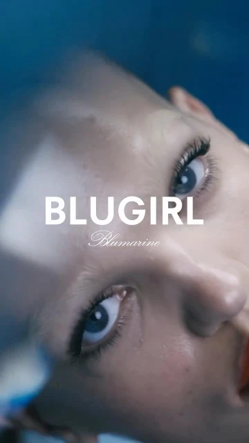 Close-up shot of a Caucasian woman's face with blue eyes looking upward against a gradient blue background, featuring 'BLUGIRL' text.