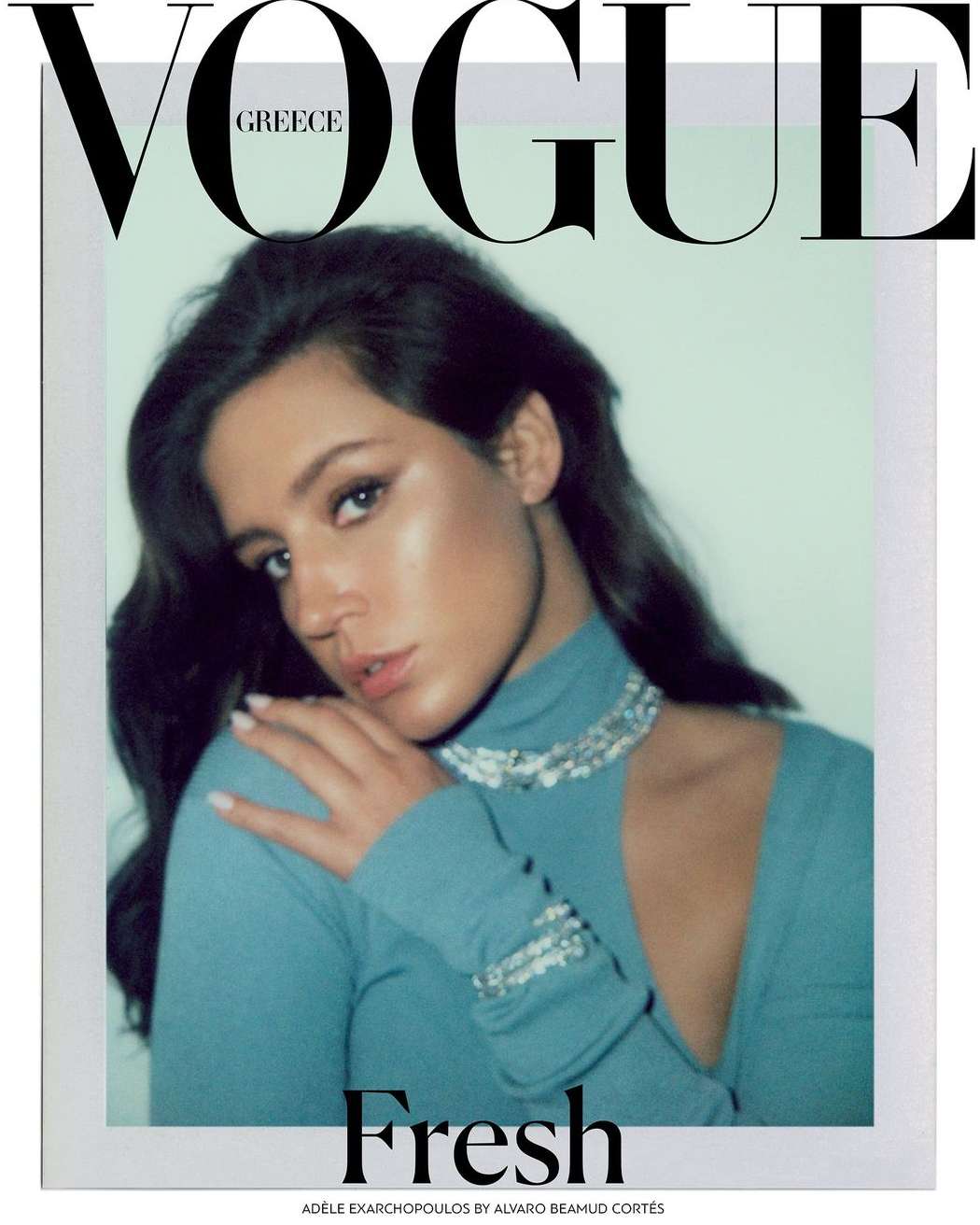 Portrait of Adele Exarchopoulos wearing a blue turtleneck top with a beaded necklace, photographed by Alvaro Beamud Cortes.