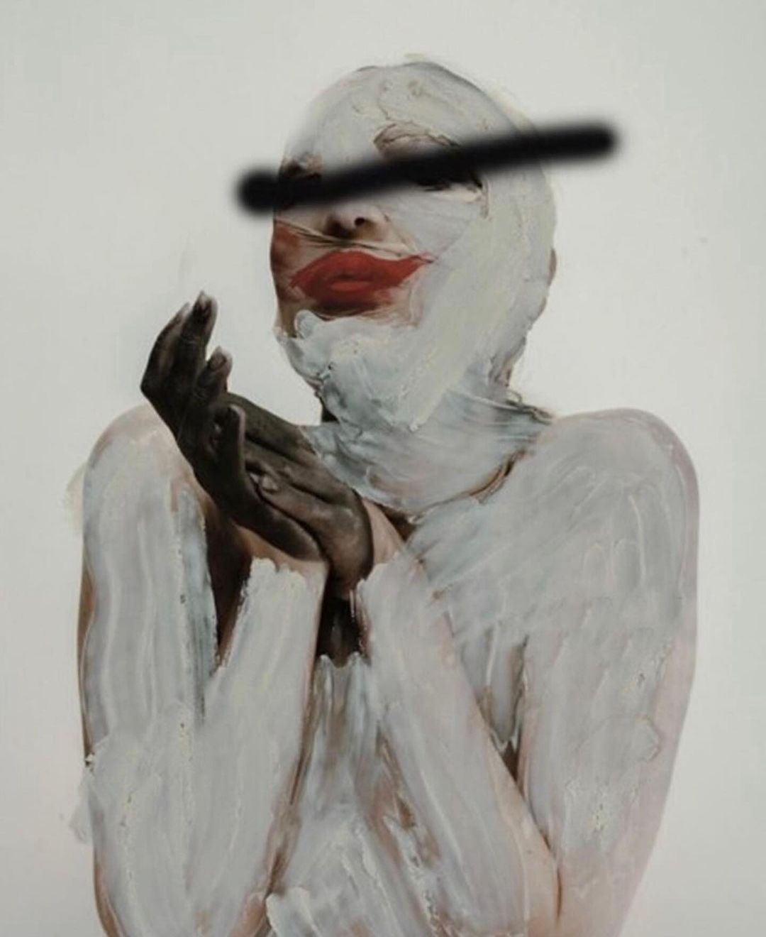 Painted woman with red lips and eyes obscured by a black bar raises her hands as if in prayer against a white backdrop.