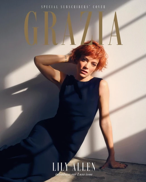 Lily Allen poses in a navy dress for a magazine cover against a light backdrop with shadows creating visual interest and depth.