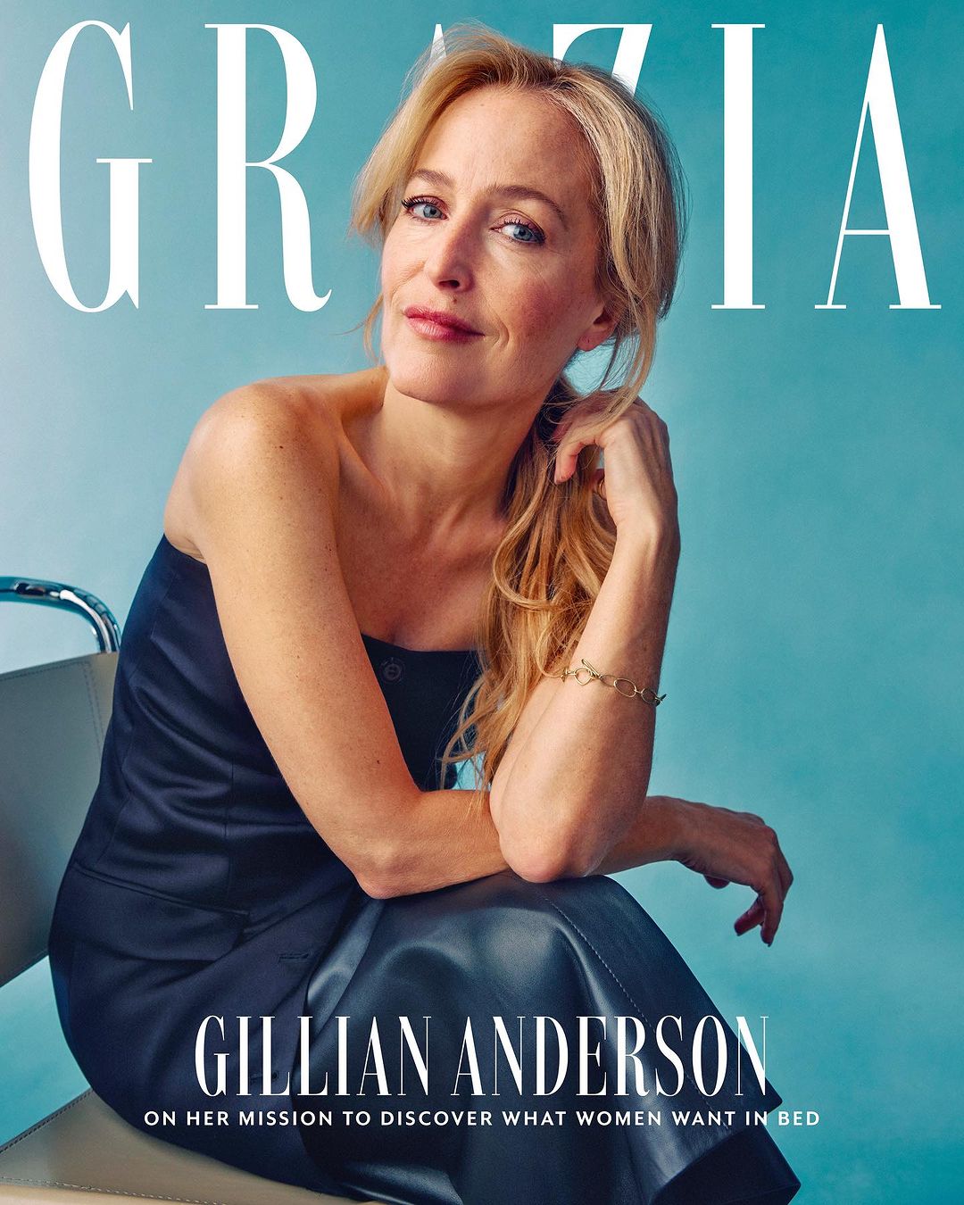 Gillian Anderson on a magazine cover in a strapless dress, seated against a light blue background with 'Grazia' printed at the top.