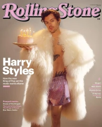 Harry Styles holding a pink birthday cake while wearing a fluffy white coat and sparkly shorts on a magazine cover.