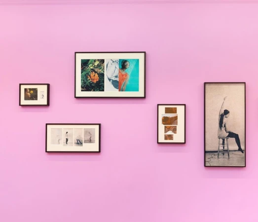 Gallery wall featuring five framed artworks arranged symmetrically on a light purple wall, creating a minimalist and contemporary art display.