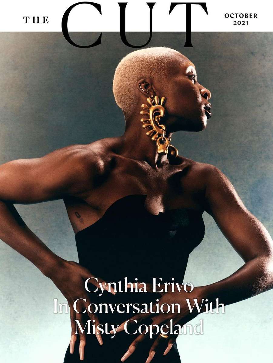 Cynthia Erivo graces The Cut's October 2021 cover, showcasing a chic short blonde haircut, strapless black dress, and elaborate gold earrings.