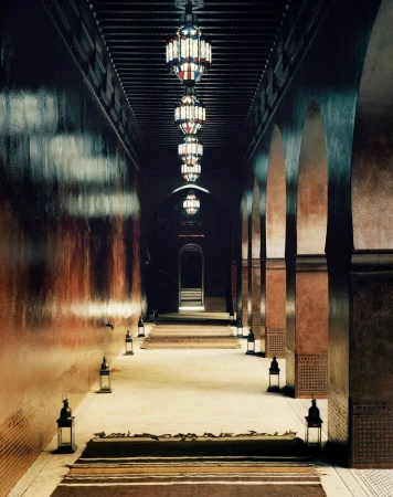 Hallway view with overhead lamps and arches lining each side, showing architecture with middle eastern design.