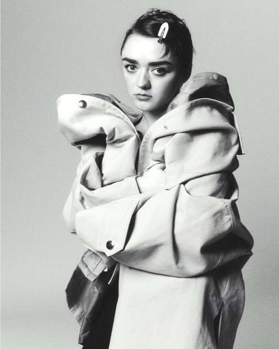 Monochrome portrait of a young woman wearing an oversized coat with an unhappy expression, and a barrette in her hair.
