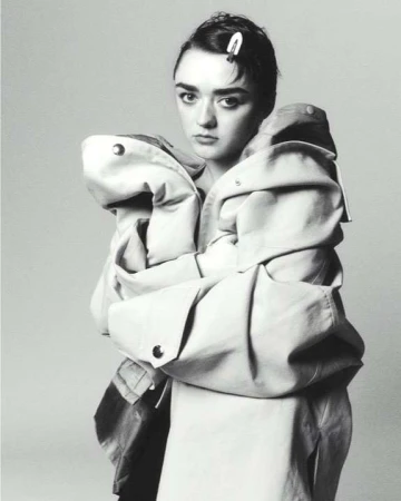 Monochrome portrait of a young woman wearing an oversized coat with an unhappy expression, and a barrette in her hair.