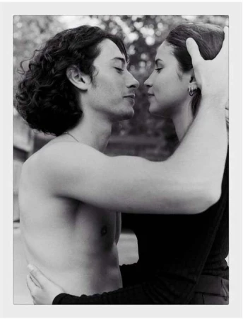 Black and white portrait of a man and woman embracing closely, shot by photographer Amit in Paris.