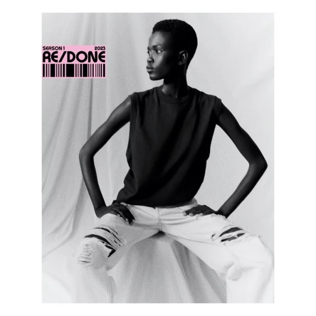 Monochrome fashion portrait of a Black woman in a sleeveless shirt and ripped jeans, posing against a white backdrop with text overlay.