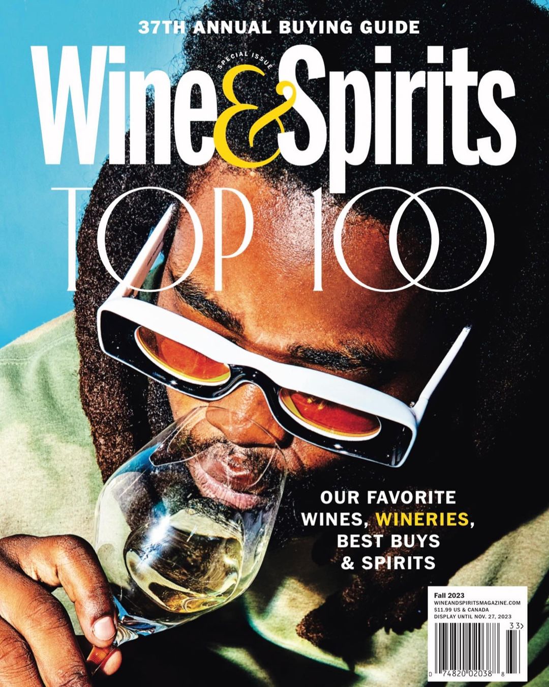 Magazine cover featuring a person in sunglasses drinking wine, with the title 'Wine & Spirits Top 100' and text about wine and wineries.