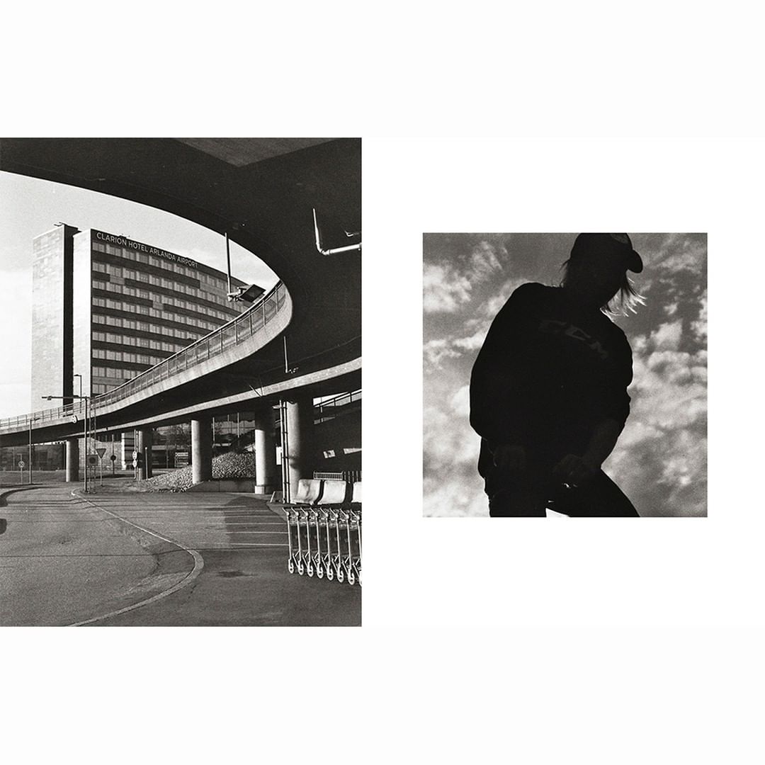 Monochrome image featuring the Clarion Hotel Arlanda Airport connected by an elevated walkway, with a silhouetted person against a cloudy sky.