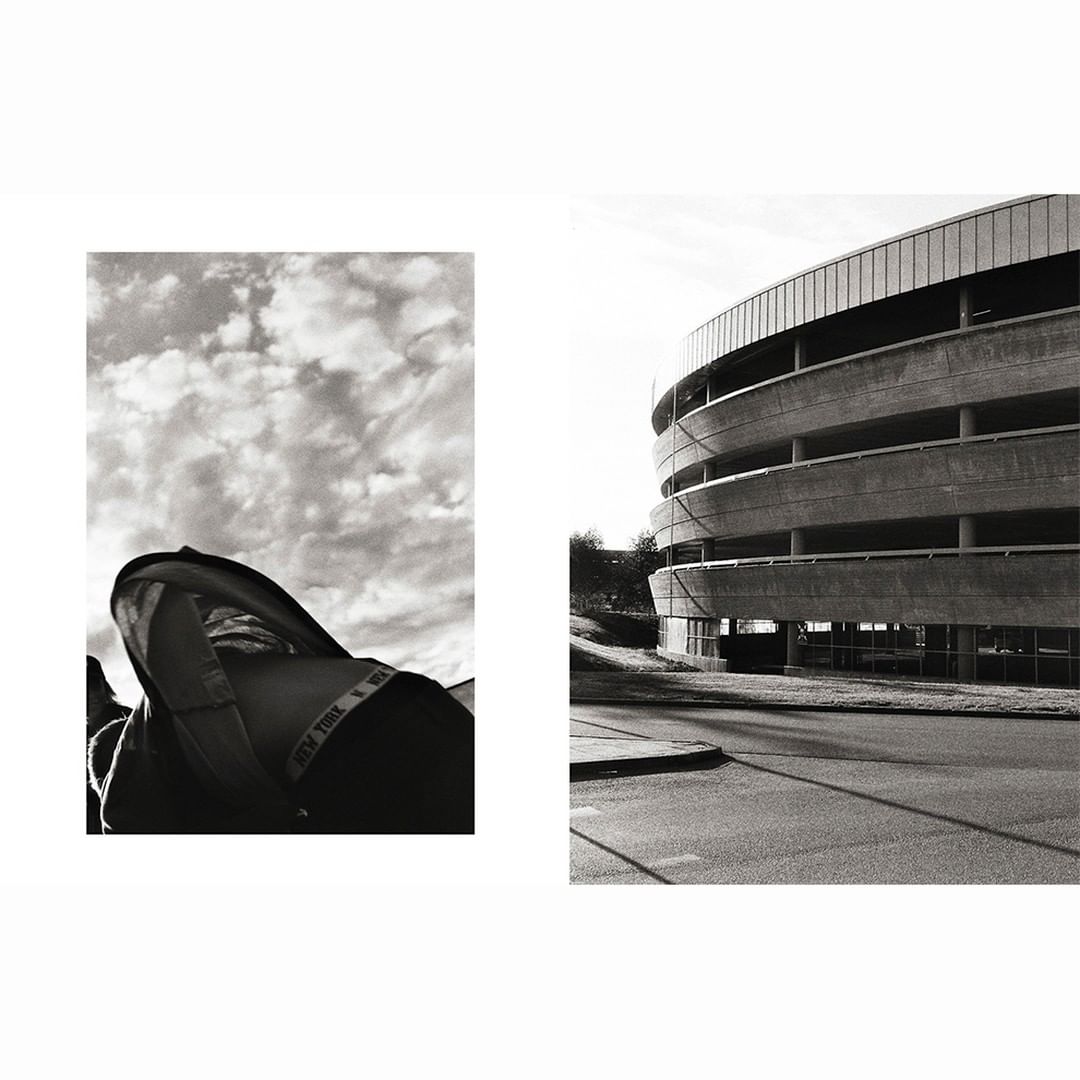 Monochrome photo showcasing a hooded jacket against a cloudy sky and an architectural parking structure against a street.