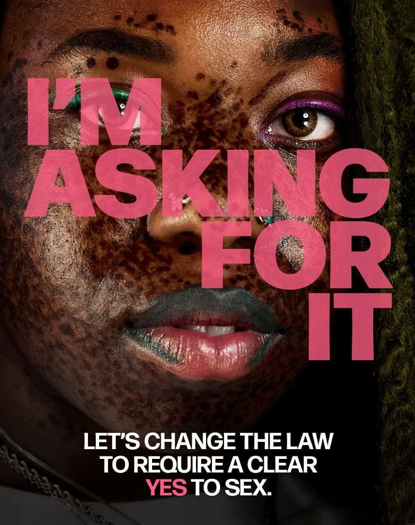 Close-up of a Black woman's face with text overlayed saying, I'm Asking For It. Additional text at bottom, Let's Change The Law To Require A Clear Yes To Sex.