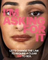 Close-up portrait of a woman wearing a dark head covering with bold pink text overlay reading I AM ASKING FOR IT.