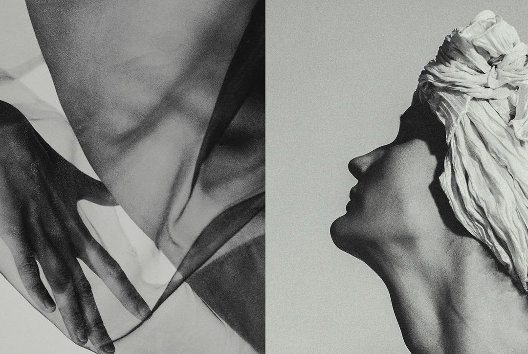 Monochrome image featuring an adult woman's face in profile, juxtaposed with a partially visible hand and draped fabric texture.