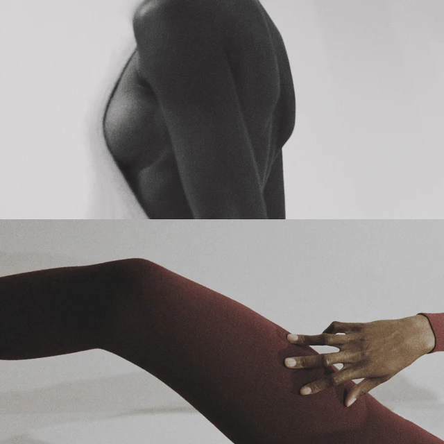 Artistic studio shot of a person's upper body in black and white and a person's leg in red bodysuit with their hand on their leg.
