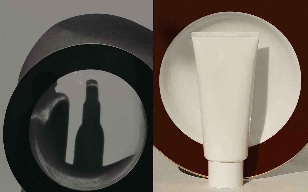 Abstract product shot featuring a white skincare tube centered on a plate, with bottle shadows cast through a rounded grey portal.