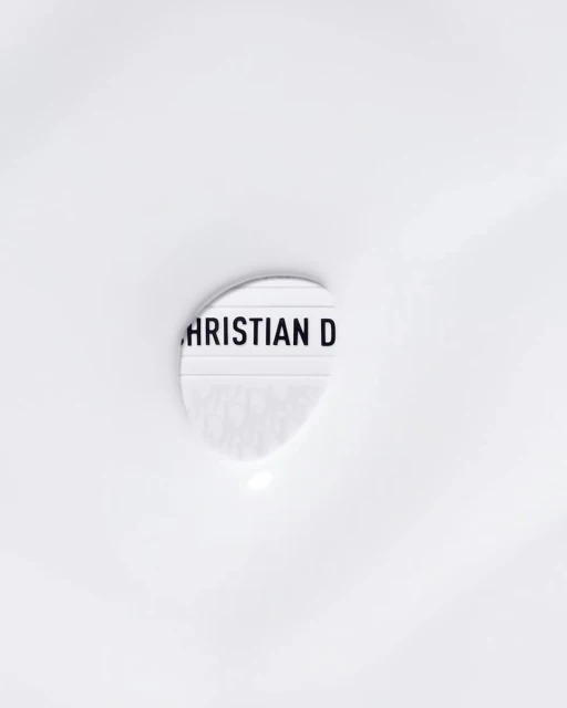 Close-up of a lightbox displaying the text 'CHRISTIAN D' against a white background, minimalist aesthetic.