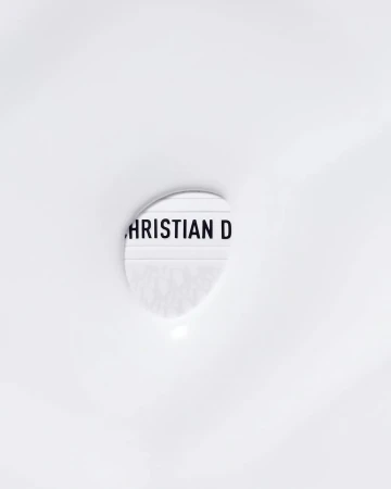 Close-up of a lightbox displaying the text 'CHRISTIAN D' against a white background, minimalist aesthetic.