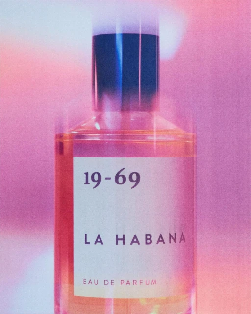 Bottle of 19-69 La Habana eau de parfum with pink background and studio lighting. Close-up shot with shallow depth of field.