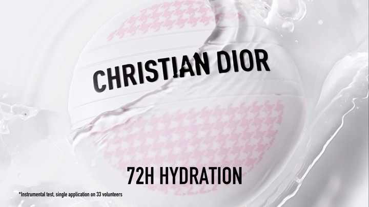 Close-up of Christian Dior skincare product with houndstooth pattern on white packaging, surrounded by white liquid for beauty ad.