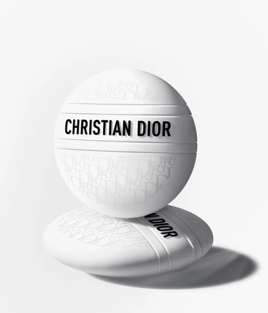 Two white Christian Dior skincare containers stacked on each other against a bright white background with a shadow beneath. Beauty shot.