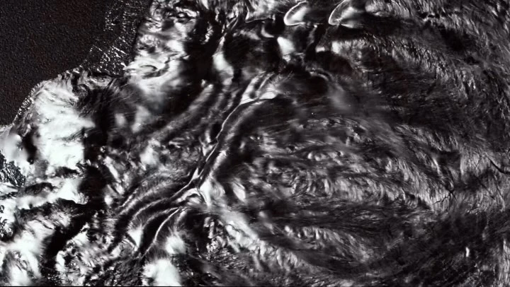 Abstract monochrome pattern of liquid or flowing material in black and white tones creating an artistic and textured surface.