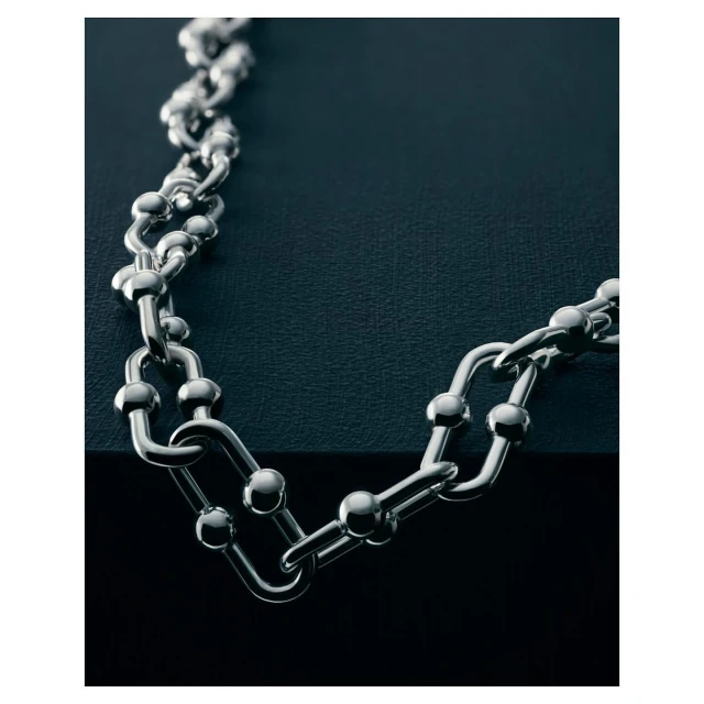 Elegant silver chain necklace with a ball and rectangular link design on a dark background, creating a luxurious and sophisticated aesthetic.