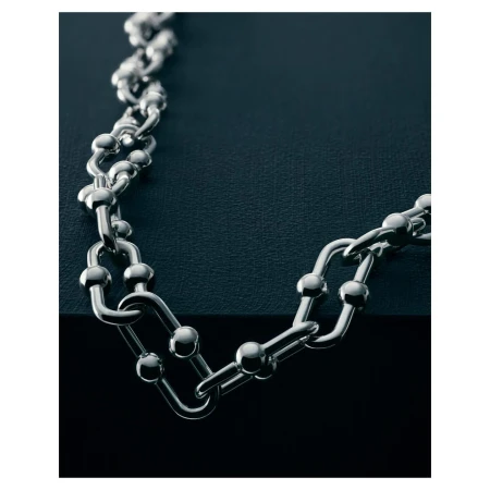 Elegant silver chain necklace with a ball and rectangular link design on a dark background, creating a luxurious and sophisticated aesthetic.