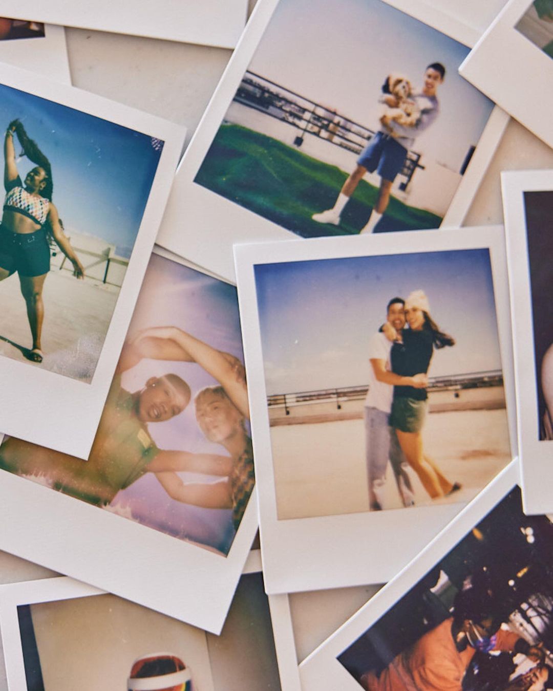 Collection of polaroid photos featuring couples, a man with a dog, and a woman in swimwear, displayed on a white surface.