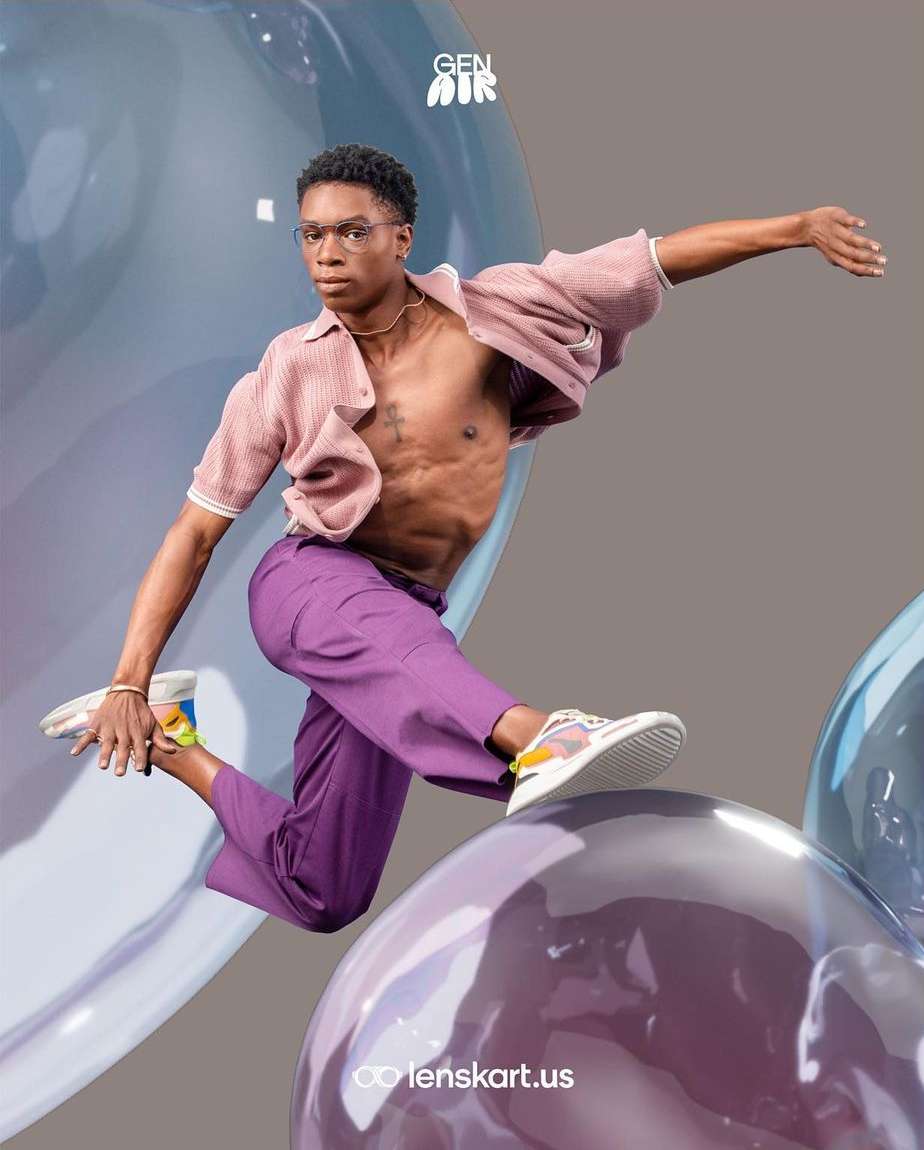 Young Black male model in glasses leaps over purple bubble, wearing casual pink top and lilac pants, for eyeglasses advertisement.