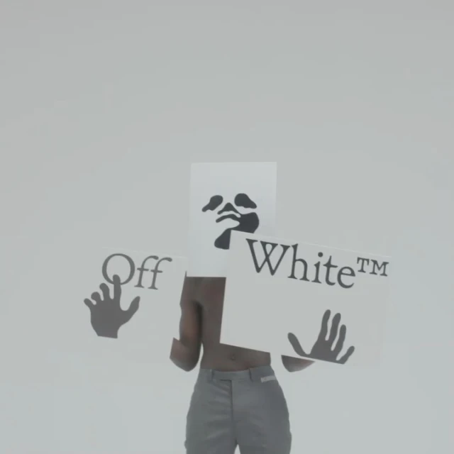 Torso shot of a man in grey pants holding Off-White branded cards with graphics in a sterile studio environment with even lighting.