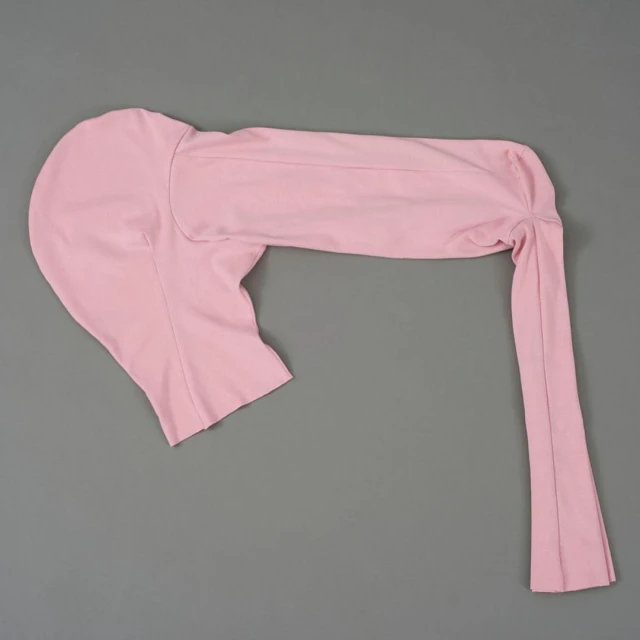 Flat lay of a one-sleeved, pink spandex or nylon garment on a grey background. Fashionable and form-fitting apparel for women.