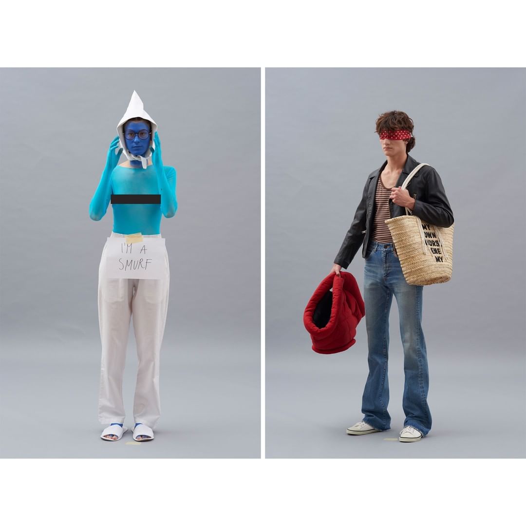 Two models pose in a photo studio against a grey backdrop: one in Smurf-like blue body paint and one in 70s-inspired fashion.